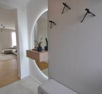 Perla v mori priemernosti - 4i prémiový RD Miloslavov - Interiér rodinného domu s podlahou s dreveným dekorom, zrkadlom a izbovými rastlinami.