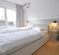 Perla v mori priemernosti - 4i prémiový RD Miloslavov - Spálňa v rodinnom dome s posteľou, rastlinou a podlahou s dreveným dekorom.