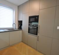 Perla v mori priemernosti - 4i prémiový RD Miloslavov - Kuchyňa v rodinnom dome s podlahou s dreveným dekorom a vstavanými spotrebičmi.