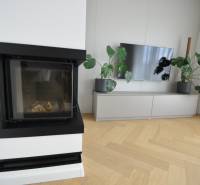 Perla v mori priemernosti - 4i prémiový RD Miloslavov - Obývačka v rodinnom dome s krbom, televízorom a podlahou s dreveným dekorom.