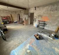 Rodinný dom na predaj, Stará Kremnička, okres Žiar nad Hronom  - Nedokončená miestnosť v rodinnom dome s bicyklom a regálmi pre rôzne nástroje.