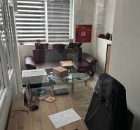 Sklad na prenájom o ploche 121 m2 s malou kanceláriou a WC - Kancelária v skladoch a halách s písacím stolom a podlahou s dreveným dekorom.