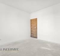 NA PREDAJ 4-IZB.BUNGALOV S DVOJGARÁŽOU,ORECHOVÁ POTôŇ - Prázdna izba v rodinnom dome s bielymi stenami a dverami s dreveným dekorom.