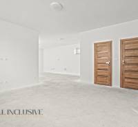 NA PREDAJ 4-IZB.BUNGALOV S DVOJGARÁŽOU,ORECHOVÁ POTôŇ - Biele steny a drevené dvere v interiéri rodinného domu s podlahou bez dekoru.