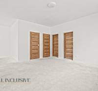 NA PREDAJ 4-IZB.BUNGALOV S DVOJGARÁŽOU,ORECHOVÁ POTôŇ - Priestranná miestnosť v rodinnom dome s bielymi stenami a dverami s dreveným dekorom.