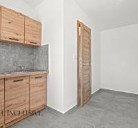 NA PREDAJ 4-IZB.BUNGALOV S DVOJGARÁŽOU,ORECHOVÁ POTôŇ - Kuchynská linka s drevodekorom a sivým obkladom v rodinnom dome, dlaždicová podlaha.