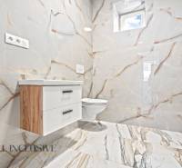 NA PREDAJ 4-IZB.BUNGALOV S DVOJGARÁŽOU,ORECHOVÁ POTôŇ - Kúpeľňa v rodinnom dome s keramickými obkladmi a nábytkom s dreveným dekorom.