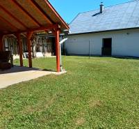 TUŽINA okres Prievidza - CHATA s terasou a garážou  - Záhrada pri chate v Tužine s prístreškom a trávnikom na slnečnom mieste.