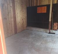 TUŽINA okres Prievidza - CHATA s terasou a garážou  - Drevený interiér chaty s betónovou podlahou a drevenými stenami.