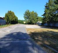 INVESTIČNÝ POZEMOK - Prievidza - Asfaltová cesta obklopená stromami a zeleňou v Prievidzi, vhodná na pozemky - bývanie.