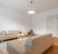 REZERVOVANÉ I Predaj charizmatického bytu Pavlovova ulica - Obývacia izba v 3-izbovom byte s pohovkami a podlahou s dreveným dekorom.