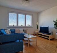 PRENÁJOM zariadený 3-izb byt, Pribišova, Bratislava - Obývačka v 3-izbovom byte s modrou pohovkou, televíziou a podlahou s dreveným dekorom.