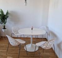 PRENÁJOM zariadený 3-izb byt, Pribišova, Bratislava - Jedálenský kút v 3-izbovom byte s podlahou s dreveným dekorom a ozdobnými stoličkami.