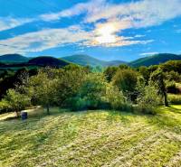 Predaj novostavba rodinného domu   Nová Baňa - Slnkom osvietená záhrada rodinného domu v Novej Bani s výhľadom na kopce.