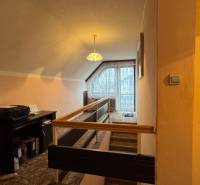 NA PREDAJ veľký rodinný dom v obci Pusté Úľany Sládkovičovo - Chodba v rodinnom dome s kobercom, dreveným zábradlím a veľkým oknom.