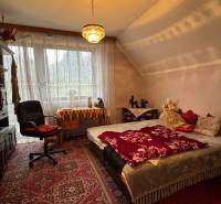 NA PREDAJ veľký rodinný dom v obci Pusté Úľany Sládkovičovo - Spálňa v rodinnom dome: koberec, posteľ, kreslo, vitrína, závesy, luster, dekorácie.