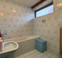 NA PREDAJ veľký rodinný dom v obci Pusté Úľany Sládkovičovo - Kúpeľňa s vaňou v rodinnom dome, bledomodré obklady, okno, umývadlo, radiátor.