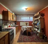 NA PREDAJ veľký rodinný dom v obci Pusté Úľany Sládkovičovo - Tradičná kuchyňa v rodinnom dome s dreveným nábytkom a červenými stenami, vybavená spotrebičmi.