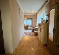 NA PREDAJ veľký rodinný dom v obci Pusté Úľany Sládkovičovo - Chodba rodinného domu s drevenou podlahou, skrinkami a pohľadom do obývačky.