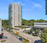 PREDAJ - LIGET Nový 2 izbový apartmán pri Sade Janka Kráľa, Petržalka - Vyhliadka z Krasovského na výškovú budovu, parkovisko a zelenú mestskú scenériu v Bratislave.