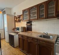 NA PRENÁJOM - 3izb.byt - Zvolenská ul. - Kuchyňa v 3-izbovom byte s drevenými skrinkami, bielou technikou a jedálenským stolom.