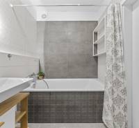 NOVOSTAVBA 2-IZB.BYT,ZÁHRADKA 26 m²,PARK.STÁTIE, MAHULANKA,PEZINOK - Kúpeľňa v 2-izbovom byte s vaňou, umývadlom a sprchovým závesom v neutrálnej farebnosti.