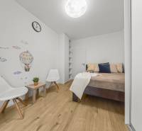 NOVOSTAVBA 2-IZB.BYT,ZÁHRADKA 26 m²,PARK.STÁTIE, MAHULANKA,PEZINOK - Spálňa v 2-izbovom byte s dekorom na stene a podlahou s dreveným dekorom.