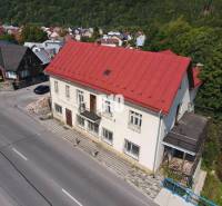 Teraz zľava 30.000 TOP INVESTIČNÁ PRÍLEŽITOSŤ Polyfunkčný objekt na pr - Budova v Belej s červenou strechou, okolité domy a príroda.