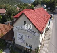 Teraz zľava 30.000 TOP INVESTIČNÁ PRÍLEŽITOSŤ Polyfunkčný objekt na pr - Budova hostinca v Belej s červenou strechou a vyobrazením na stene.