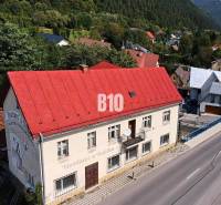 Teraz zľava 30.000 TOP INVESTIČNÁ PRÍLEŽITOSŤ Polyfunkčný objekt na pr - Budova v Belej s červenou strechou na hlavnej ulici obklopená zeleňou a domami.