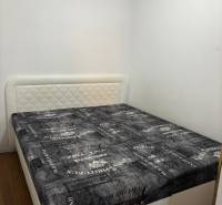 ZARIADENÁ NOVOSTAVBA 1, 5 izb. bytu- DUBOVÝ VŔŠOK - Spálňa v 2-izbovom byte s posteľou, svetlými stenami a podlahou s dreveným dekorom.