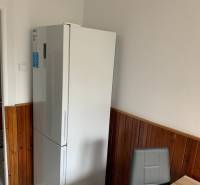 2-izb. byt, Nobelova ul., Nové Mesto, 2.p./7, balkón - Kuchyňa v 2-izbovom byte s chladničkou, tmavým obkladom a jedálenským kútom.