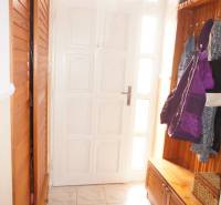 Rodinný dom v obci Čilížska Radváň s veľkým pozemkom - Vstupná hala s bielymi dverami, vešiakom a úložným boxom v rodinnom dome.