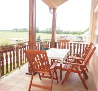 Rodinný dom v obci Čilížska Radváň s veľkým pozemkom - Rodinný dom má terasu s drevenými stoličkami a stolíkom, výhľad na záhradu.