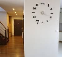 Novinka: Moderný  4-izb. mezonetový byt s balkónom a terasou. Muškát - Interiér 4-izbového bytu s hodinami na stene a podlahou s dreveným dekorom.