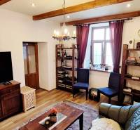 NA PRENÁJOM – odstúpenie vinotéky v srdci Starého Mesta s dušou vína - Obývacia izba s podlahou s dreveným dekorom, televízorom, policami a pohodlným nábytkom.