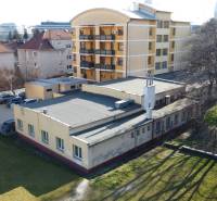 VIACÚČELOVÁ BUDOVA  - OBJEKT KOLKÁREŇ - TURČIANSKA, BRATISLAVA - Na ulici Turčianska sa nachádza nízka budova, obklopená obytnými domami a zeleňou.