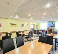 VIACÚČELOVÁ BUDOVA - OBJEKT KOLKÁREŇ - TURČIANSKA, BRATISLAVA - Na ulici Turčianska v interiéri budovy sú stolíky a stoličky, dekorácie na stenách.