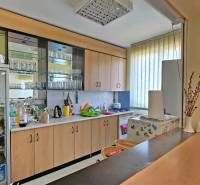 VIACÚČELOVÁ BUDOVA - OBJEKT KOLKÁREŇ - TURČIANSKA, BRATISLAVA - Kuchyňa so sklenenou vitrínou a spotrebičmi na Turčianskej ulici, interiér vo svetlých odtieňoch.