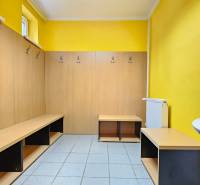 VIACÚČELOVÁ BUDOVA - OBJEKT KOLKÁREŇ - TURČIANSKA, BRATISLAVA - Šatňa s drevenými lavičkami a háčikmi, umývadlo, dlažba, steny žlté na ulici Turčianska.