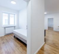 Krásny, priestranný 3i byt 71m2, v tichom dvore, úplne nový - Svetlý 3-izbový byt s posteľou a podlahou s dreveným dekorom.