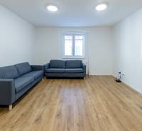 Krásny, priestranný 3i byt 71m2, v tichom dvore, úplne nový - Obývacia izba v 3-izbovom byte s pohovkou a podlahou s dreveným dekorom.