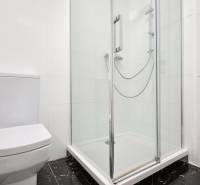 VELKOMETRÁŽNY 1 IZB.AP.BYT- TRNAVSKÁ CESTA, RUŽINOV, BRATISLAVA - Kúpeľňa v 1-izbovom byte s toaletou a sprchovým kútom, biela dlažba.