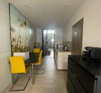 Na prenájom komerčné priestory v priemyselnej zóne v Trenčíne - Obchodné priestory s jedálenským stolom, žltými stoličkami a kuchynkou.