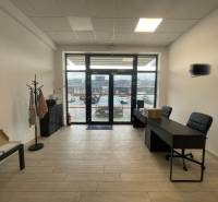 Na prenájom komerčné priestory v priemyselnej zóne v Trenčíne - Interiér obchodných priestorov s nábytkom a podlahou s dreveným dekorom.