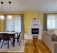 NA PREDAJ ÚTULNÝ, 4 IZBOVÝ RODINNÝ DOM S TERASOU A GARÁŽOU, IŽA - Obývačka s krbom, jedálenským stolom a podlahou s dreveným dekorom v rodinnom dome.