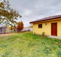 NA PREDAJ ÚTULNÝ, 4 IZBOVÝ RODINNÝ DOM S TERASOU A GARÁŽOU, IŽA - Záhrada pri rodinnom dome na Ďatelinovej ulici v Iži s dreveným prístreškom na dvore.