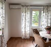 2-izbový byt v Seredi- bez rezervačnej zálohy - Jedáleň v 2-izbovom byte s podlahou s dreveným dekorom a klimatizáciou.