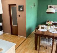 5-izbový rodinný dom v Borskom Mikuláši - bez rezervačej zálohy - Jedáleň rodinného domu so zelenými stenami, dreveným stolom a podlahou s dreveným dekorom.