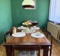 5-izbový rodinný dom v Borskom Mikuláši - bez rezervačej zálohy - Jedáleň v rodinnom dome s dreveným stolom, zelenou stenou a dekoráciami.